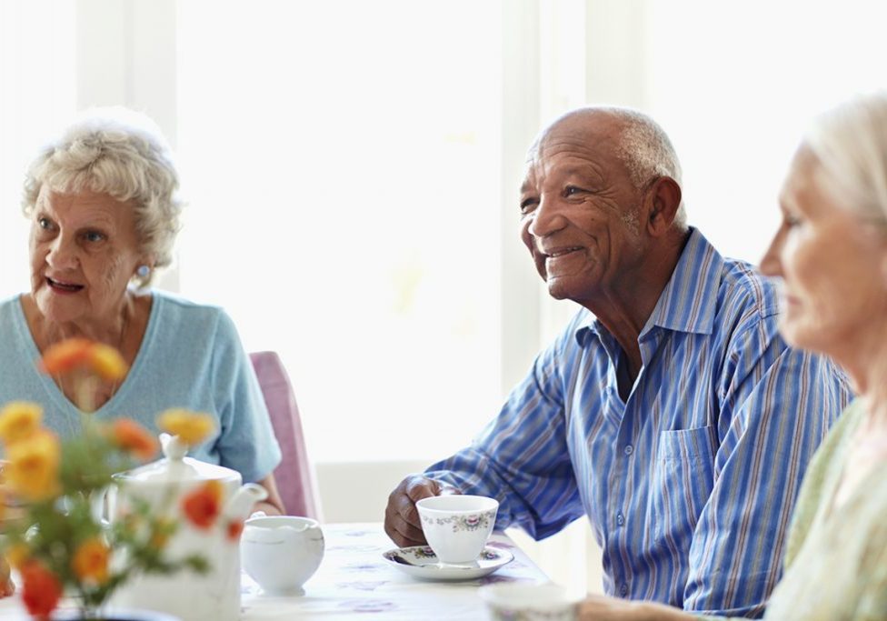 Senior friends having breakfast at table